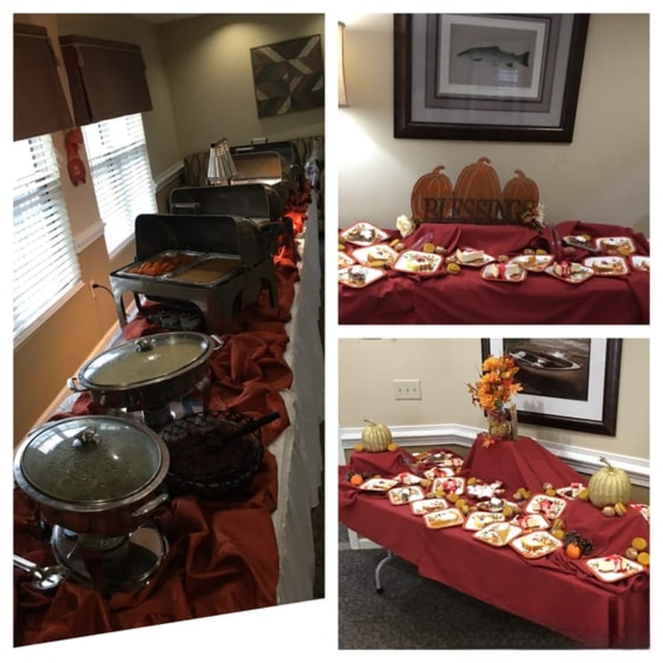 A soul food buffet with chafing dishes and dessert tables adorned with autumn decorations.